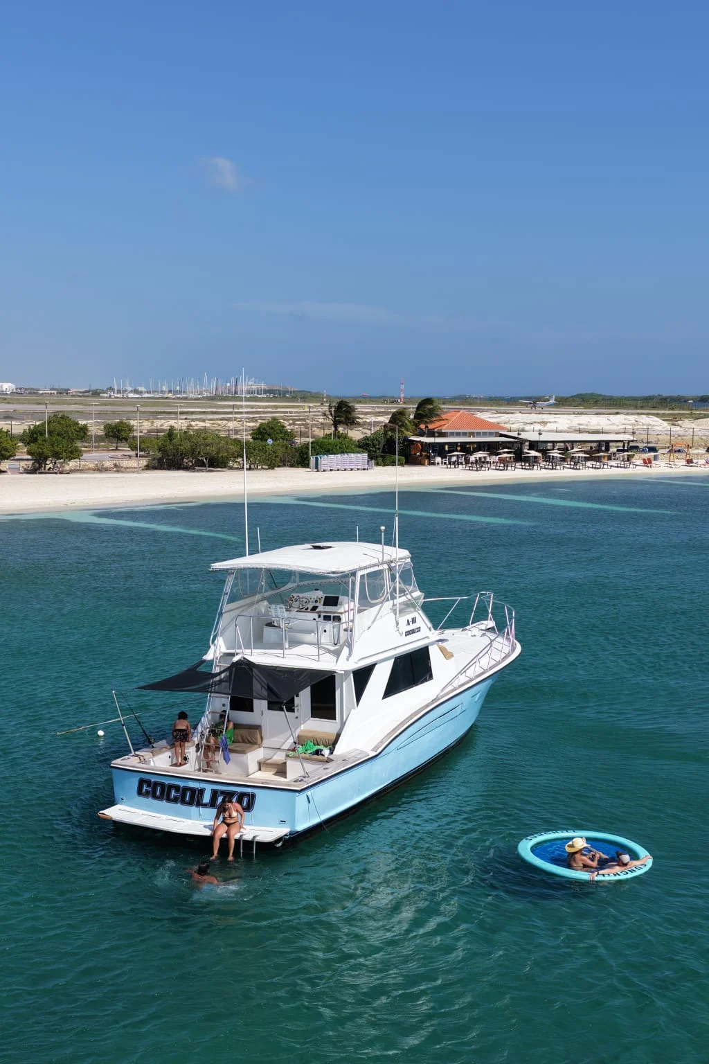 Romantic yacht getaway in Aruba — couple swimming and floating beside the yacht