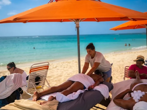 Therapist giving a beach massage beside the turquoise sea in Aruba