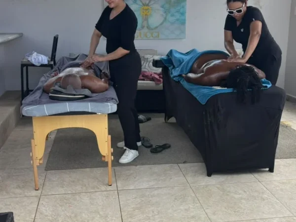 Two guests receiving massages side by side in a villa living room