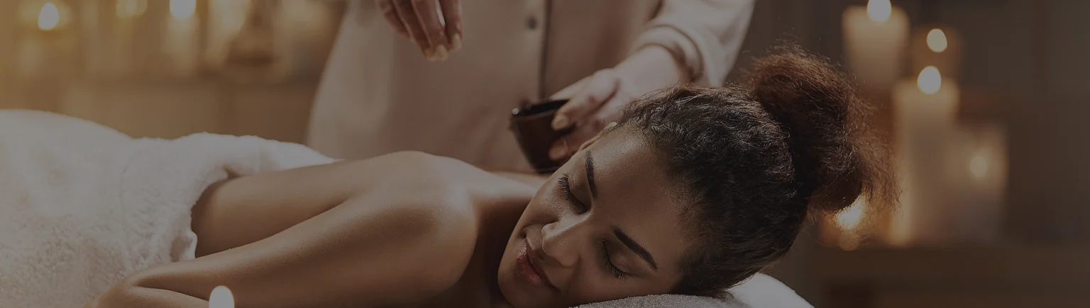 Relaxed guest on a massage table with candles